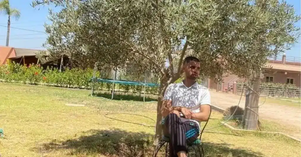 Othmane sitting under an olive tree in rural Morocco, reflecting on Morocco tours 2025