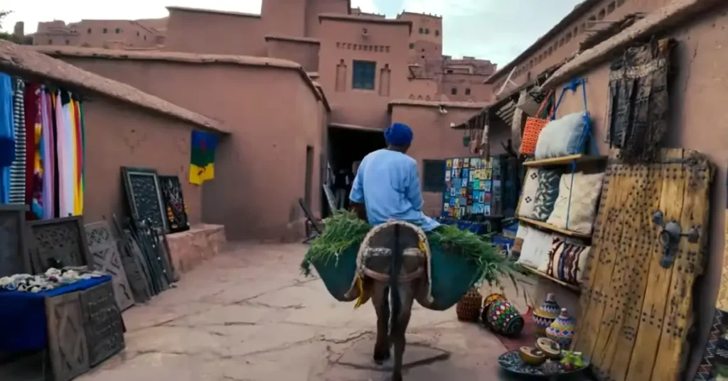 Berber man riding a donkey through Ait Ben Haddou village market