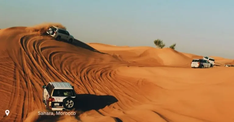 4x4 vehicles climbing the sand dunes in Morocco’s deep Sahara region