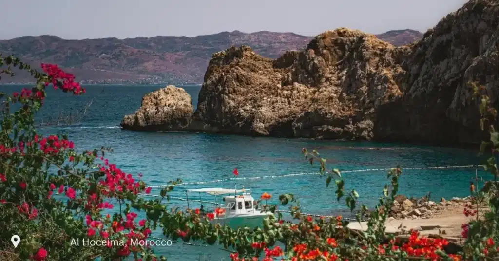 Coastal view of Al Hoceima with fishing boat and Rif mountains – Morocco small group tours
